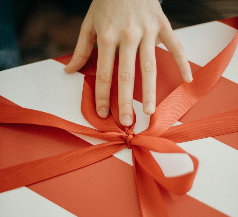A person carefully wrapping a Christmas present. 