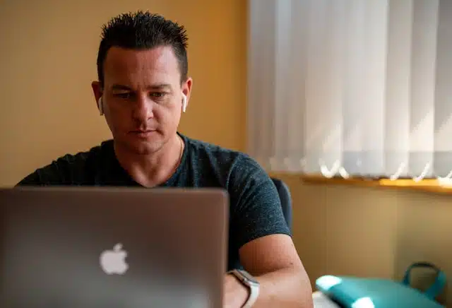 A man applying for a title pawn online from the comfort of his home, using a laptop.