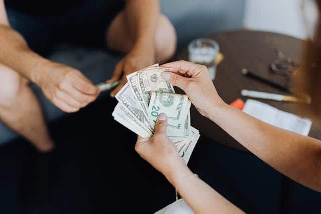 A person handing over a car title loan to another